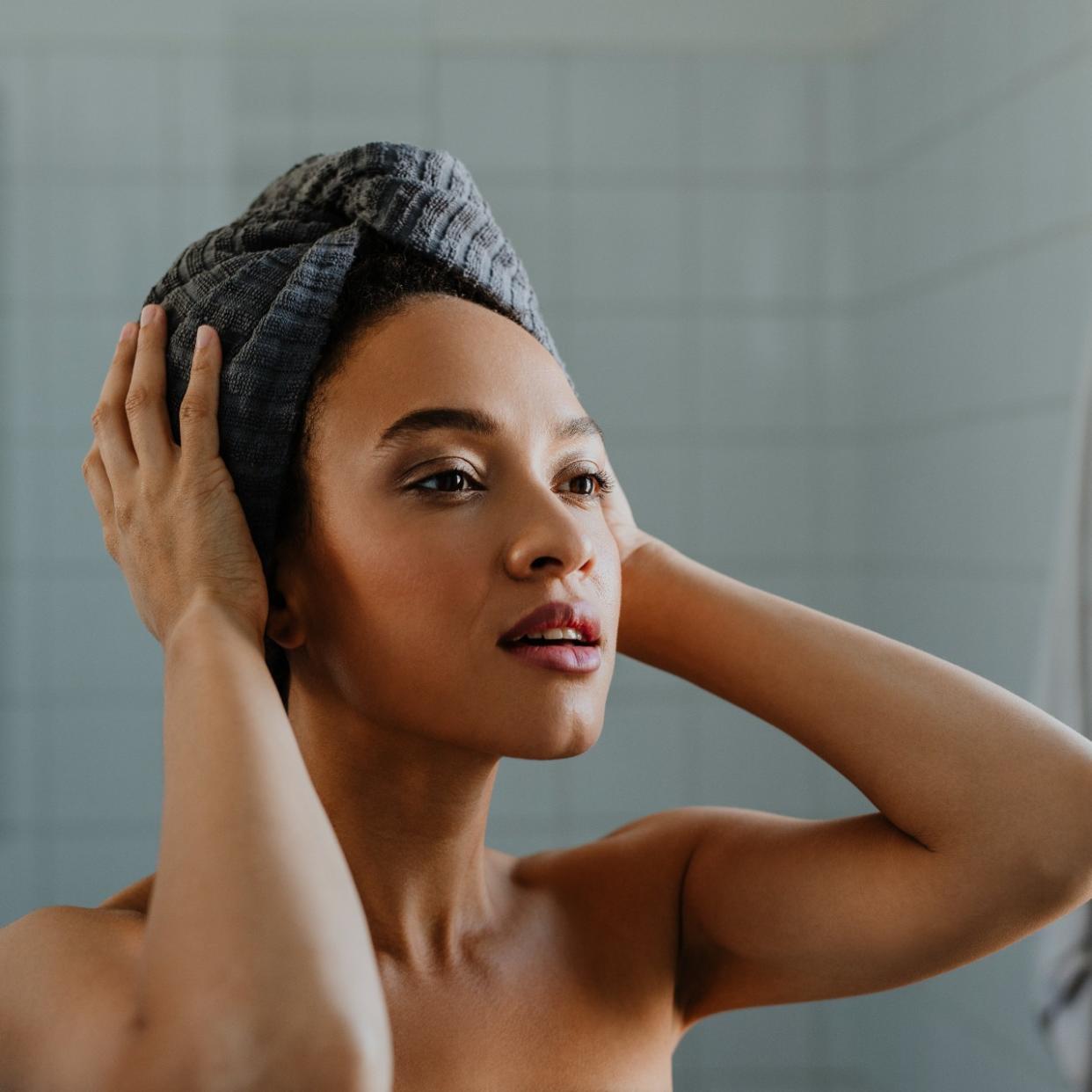  A portrait of a young woman after washing her hair, with a towel wrapped over her head. 