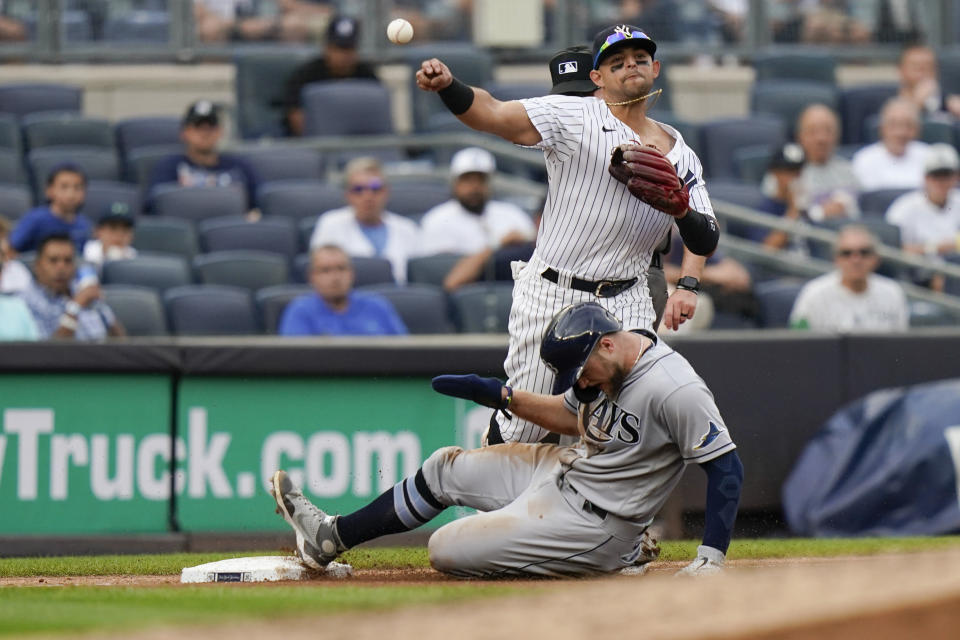 New York Yankees second baseman Rougned Odor, top, throws to first base after forcing out Tampa Bay Rays' Austin Meadows, bottom, during the fourth inning of a baseball game Sunday, Oct. 3, 2021, in New York. Mike Zunino was safe at first on the play. (AP Photo/Frank Franklin II)