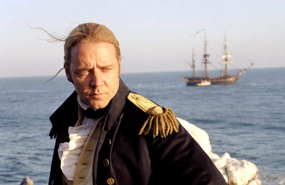 A man stands on a ship out on the ocean