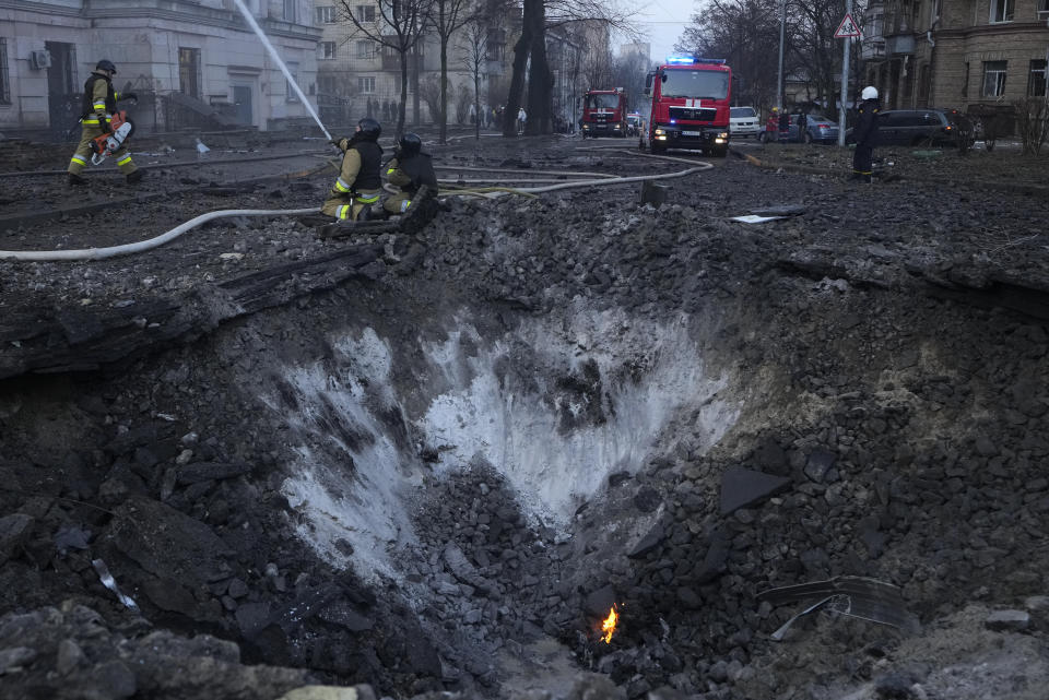 Firefighters work near the crater at the site after a Russian attack in Kyiv, Ukraine, Thursday, March 21, 2024. Around 30 cruise and ballistic missiles were shot down over Kyiv on Thursday morning, said Serhii Popko, the head of Kyiv City Administration. The missiles were entering Kyiv simultaneously from various directions in a first missile attack on the capital in 44 days. (AP Photo/Vadim Ghirda)