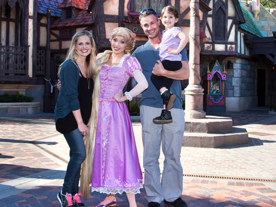 Sarah Michelle Gellar, Freddie Prinze Jr., and their daughter Charlotte pose for a photo with Rapunzel at Disneyland in 2013.