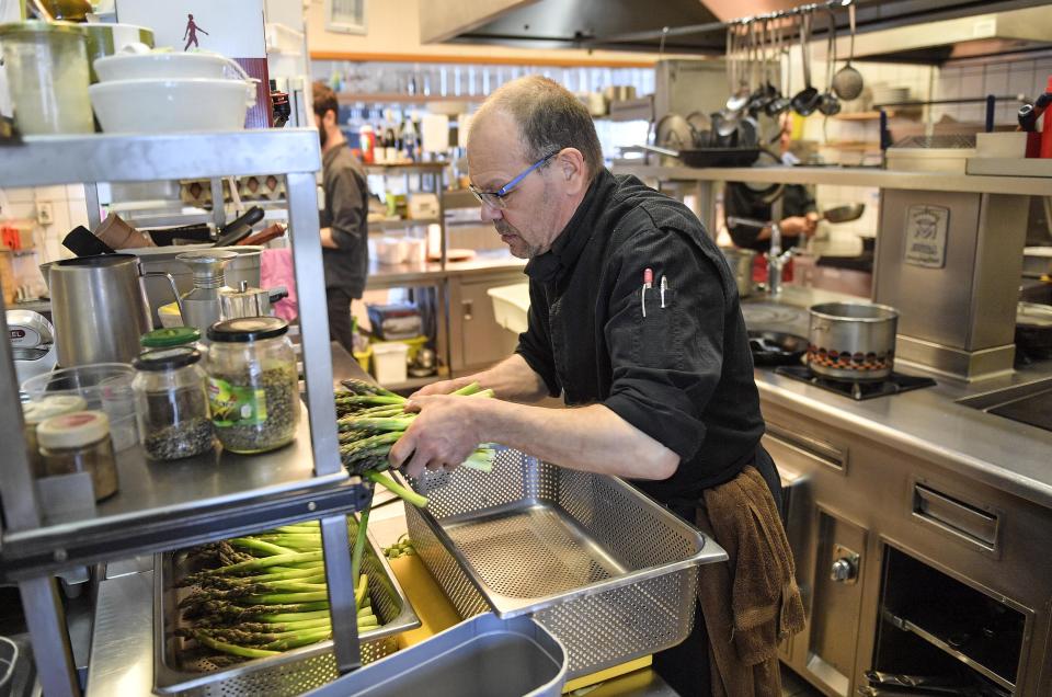 In this photo taken on Wednesday, May 15, 2019, Restaurateur Michael Recktenwald, who has taken legal action against the EU to protect climate walks on the beach near his restaurant, cooks on the car-free environmental island of Langeoog in the North Sea, Germany. Concerns about climate change have prompted mass protests across Europe for the past year and are expected to draw tens of thousands onto the streets again Friday, May 24. For the first time, the issue is predicted to have a significant impact on this week’s elections for the European Parliament. (AP Photo/Martin Meissner)