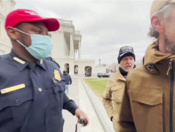 Capitol Police officer Lt. Tarik Khalid Johnson wearing a red MAGA hat trying to recruit Trump supporters to help him gain control of the crowd during the Capitol insurrection on 6 January 2021.  (Screengrab via Rico La Starza video)