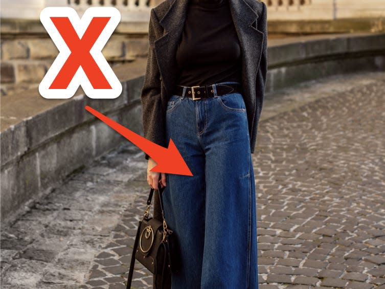 red x and arrow pointing to woman wearing wide leg dark wash jeans and a black top
