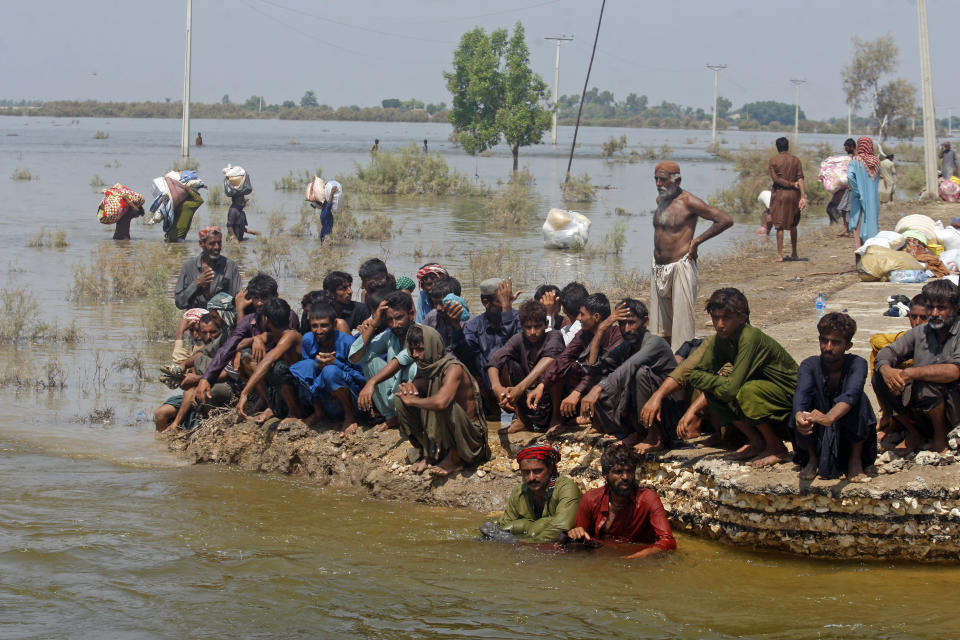 Victims of heavy flooding from monsoon rains wait to receive relief aid from the Pakistani Army in the Qambar Shahdadkot district of Sindh Province, Pakistan, Friday, Sept. 9, 2022. U.N. Secretary-General Antonio Guterres appealed to the world for help for cash-strapped Pakistan after arriving in the country Friday to see the climate-induced devastation from months of deadly record floods. (AP Photo/Fareed Khan)