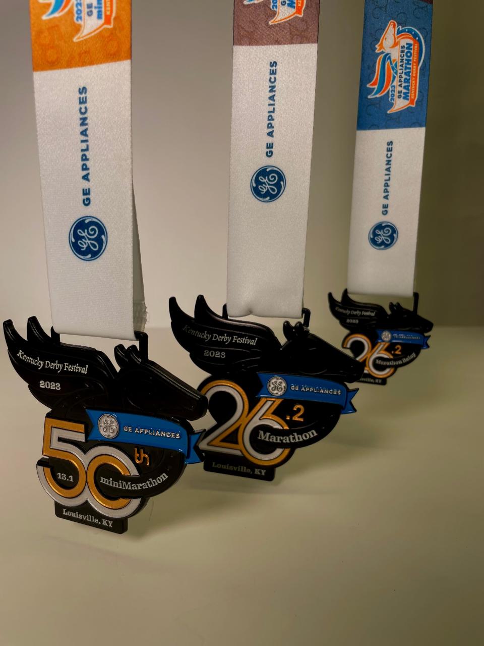 The commemorative 50th anniversary finishers medal for 2023 GE Appliances KDF miniMarathon plus full marathon and relay medals.