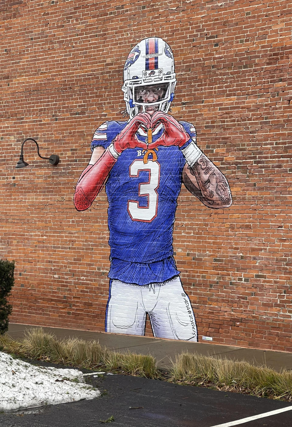 A mural by artist Adam Zyglis of Buffalo Bills player Damar Hamlin, who is recovering after going into cardiac arrest during a game Jan. 2, covers the outside of a building in Buffalo, N.Y., on Wednesday, Jan. 18, 2023. (AP Photo/Carolyn Thompson)