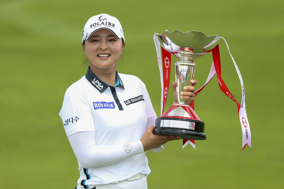 Jin Young Ko of South Korea holds the championship trophy after winning the Women's World Championship of golf at Sentosa Golf Club in Singapore, Sunday, March 6, 2022. (AP Photo/Paul Miller)