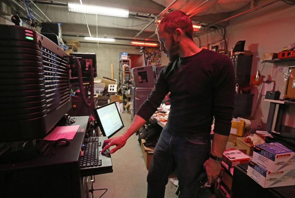 In this April 4, 2014 photo, projectionist Randall Harper operates one of the digital cinema projectors at the three-screen SIE Film Center, a movie theater run by the Denver Film Society, in Denver. As movie theaters small and large are increasingly obliged to upgrade their systems from actual film to expensive digital movie projection, Denver Film Society, the Gates Family Foundation and others are offering grants to small-town locally owned theaters so they can afford the transition. (AP Photo/Brennan Linsley)