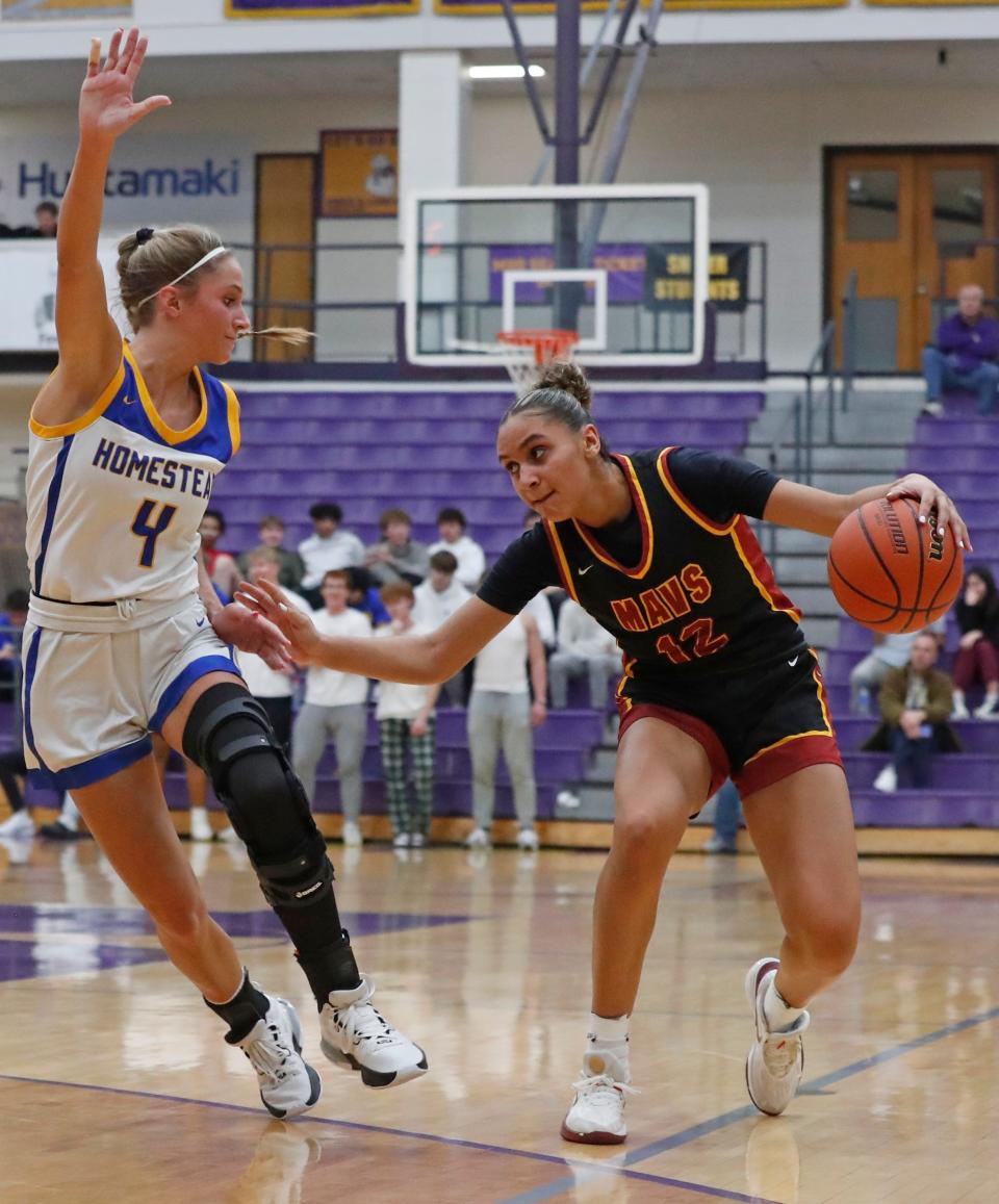 Homestead Spartans Emma Reust (4) defends McCutcheon Mavericks Lillie Graves (12) during the IHSAA girl’s basketball regional game, Saturday, Feb. 10, 2024, at Marion High School in Marion, Ind. Homestead Spartans won 51-34.