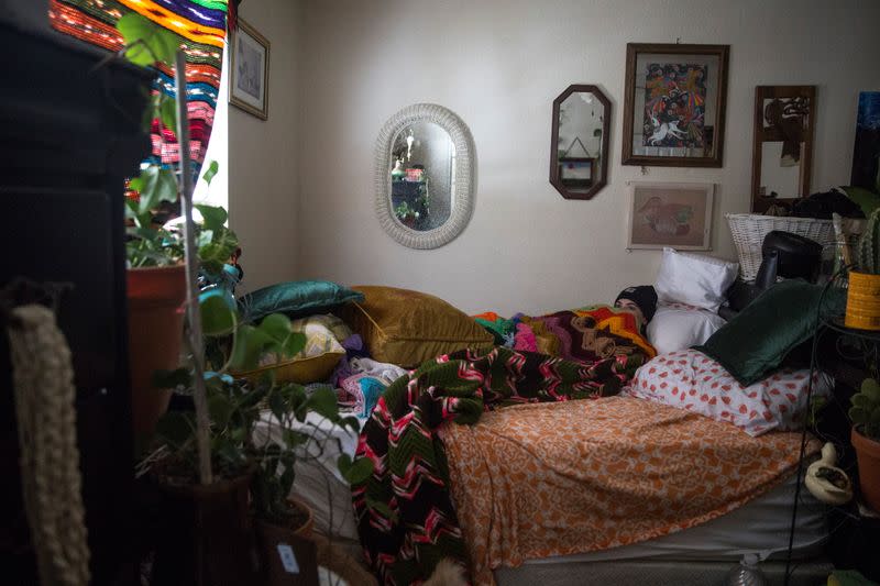 KD Nance huddles under layers of clothing and blankets in their room after winter weather caused electricity blackouts in San Marcos