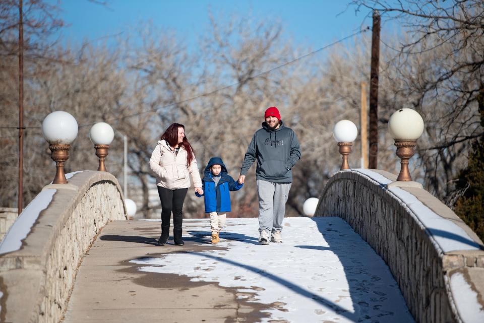 Sarah Huff, Zaaden Gallegos, 5, and Gabriel Gallegos walk over the bridge at Mineral Palace Park on Tuesday, January 16, 2024.