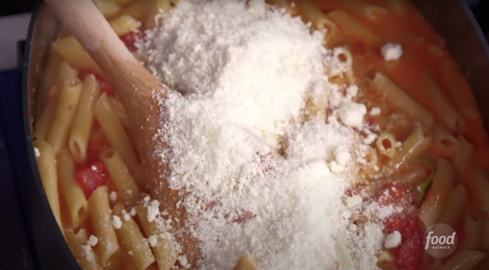 parmesan on top of a red sauce pasta