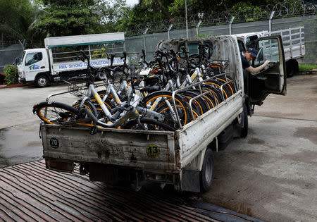 Zhivko Girginov, a Bulgarian living in Singapore, return damaged Obikes to their warehouse after gathering them around his neighbourhood in Singapore December 29, 2017. Picture taken December 29, 2017. REUTERS/Edgar Su