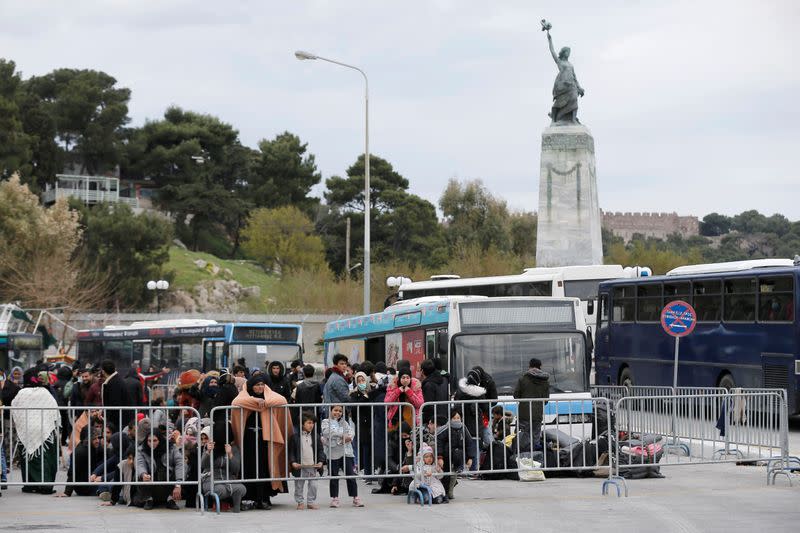 Migrants who arrived on the island of Lesbos in the past four days, are seen at the port of Mytilene, as they wait to board a Greek navy ship, in Mytilene