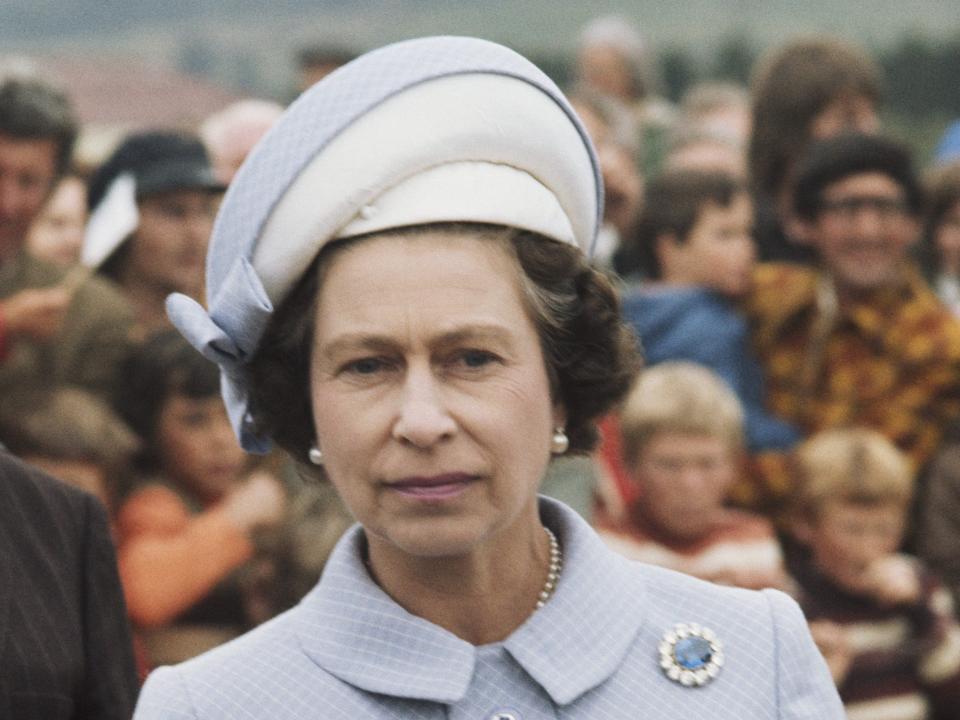 Queen Elizabeth in 1977 wearing a blue suit and hat