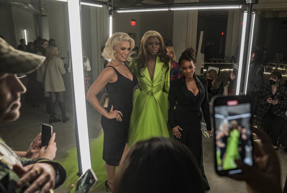 Front row celebrities Hannah Waddingham, left, Symone, center, and Anika Noni Rose, right, pose for photos before viewing Christian Siriano's fall/winter 2022 fashion collection during Fashion Week, Saturday Feb. 12, 2022, in New York. (AP Photo/Bebeto Matthews)