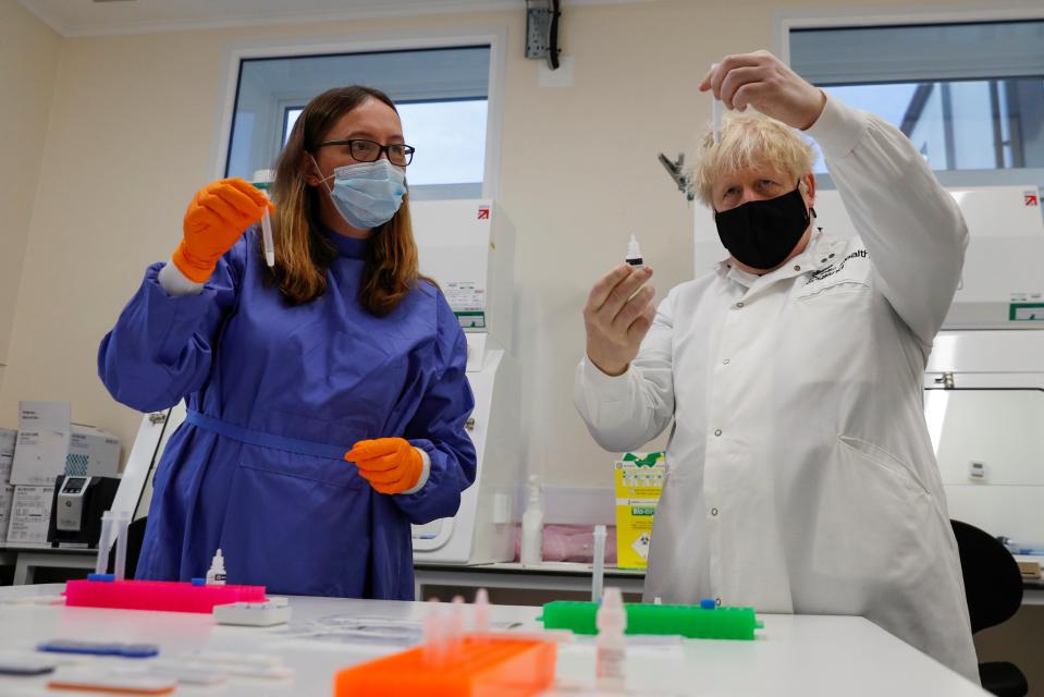 <p>Boris Johnson looks at samples at the Lateral Flow Testing Laboratory with Doctor Abbie Bown</p> (REUTERS)