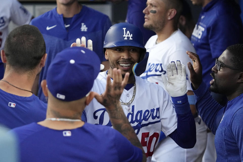 Los Angeles Dodgers' Mookie Betts is congratulated by teammates in the dugout after hitting a solo home run during the third inning of a baseball game against the Los Angeles Angels Friday, July 7, 2023, in Los Angeles. (AP Photo/Mark J. Terrill)