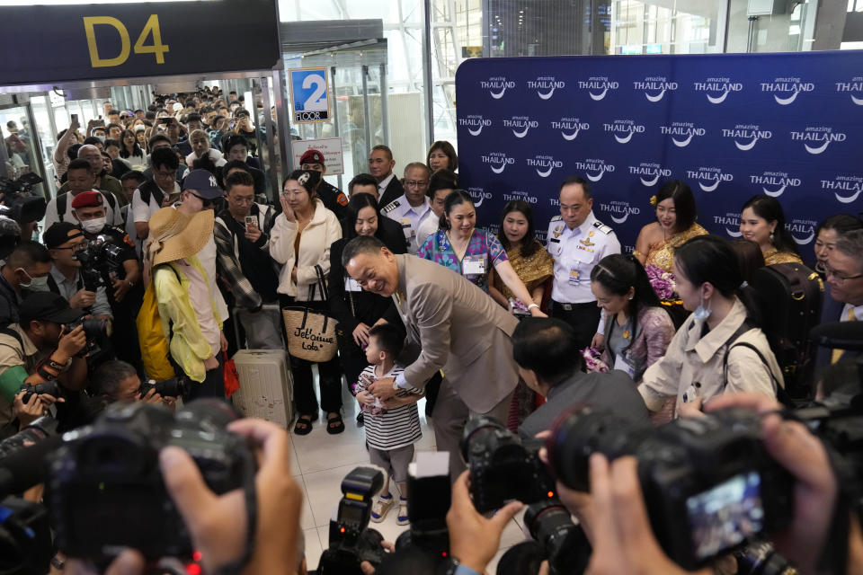 Chinese boy tourists are welcomed by Thailand's Prime Minister Srettha Thavisin, right, on their arrivals at Suvarnabhumi International Airport in Samut Prakarn province, Thailand, Monday, Sept. 25, 2023. Thailand's new government granting temporary visa-free entry to Chinese tourists, signaling that the recovery of the country's tourism industry is a top economic priority. (AP Photo/Sakchai Lalit)