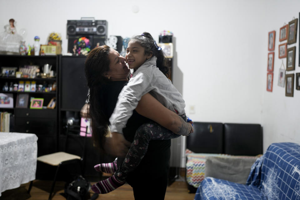 Susana Martínez holds her daughter Valentina Jiménez at their home in Buenos Aires, Argentina, Thursday, May 11, 2023. Martínez is struggling to make ends meet and in the last few months is finding it impossible to buy certain products that were once staples, such as yogurt. (AP Photo/Natacha Pisarenko)