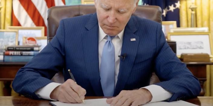 President Joe Biden at the Resolute Desk vetoes a GOP-led effort to roll back his student debt relief measures on June 7, 2023.