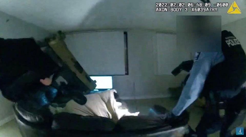 Police point their guns at Amir Locke as he lies on a sofa under a blanket before being shot (Minneapolis Police Department/AF)