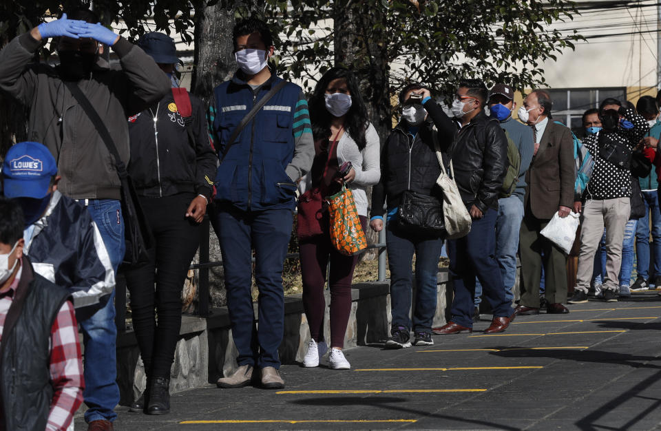 Commuters wearing masks as a precaution against the spread of the new coronavirus line up, keeping distance, at a cable car station in La Paz, Bolivia, Monday, June 1, 2020. The cable restarted operations, with a reduced number of passengers per gondola, as the total lockdown begins to ease. (AP Photo/Juan Karita)