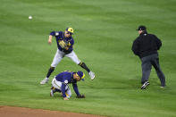 Milwaukee Brewers' Luis Urias throws to first base but is unable to make an out on an infield hit by Philadelphia Phillies' Odubel Herrera as Kolten Wong ducks away from the throw during the seventh inning of a baseball game, Monday, May 3, 2021, in Philadelphia. (AP Photo/Derik Hamilton)