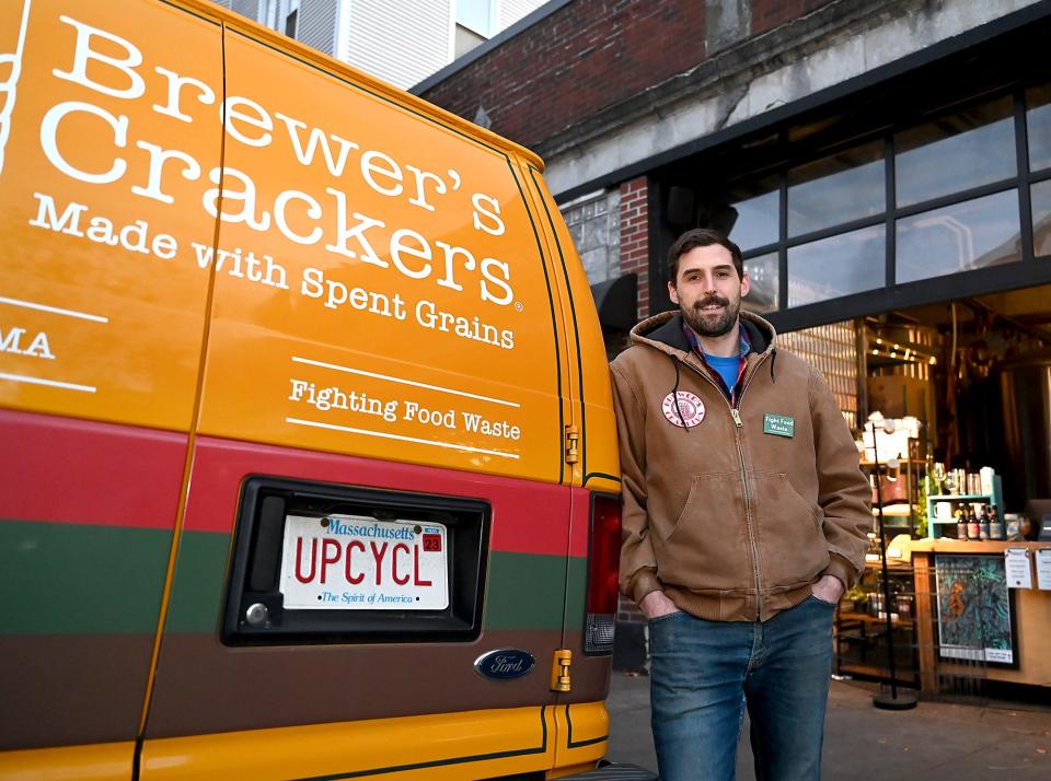 Kyle Fiasconaro, owner of Brewer's Foods, with his van as it is parked at Lamplighter Brewing Company in Cambridge Friday. Fiasconaro makes his crackers, chips and cookies from the left-over grain used for brewing beer at Lamplighter and other breweries.