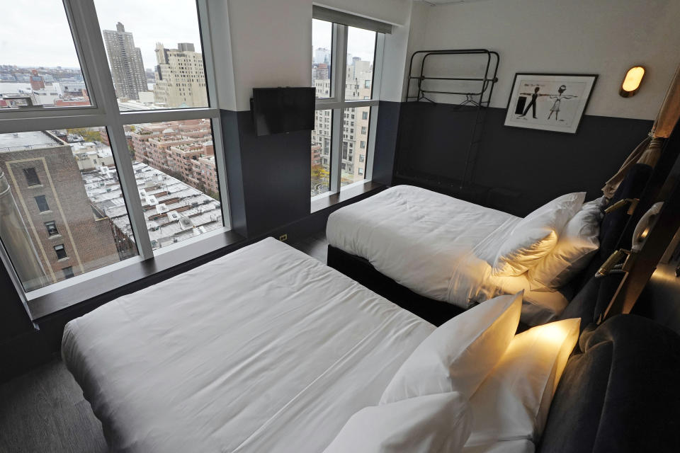 A room with double beds appear at the new hotel Civilian in New York's Theater District, Monday, Nov. 15, 2021. The 203-room hotel is packed with hundreds of pieces of Broadway art, including sketches, set models, costume pieces, photographs and artifacts that show theater past and present. (AP Photo/Richard Drew)