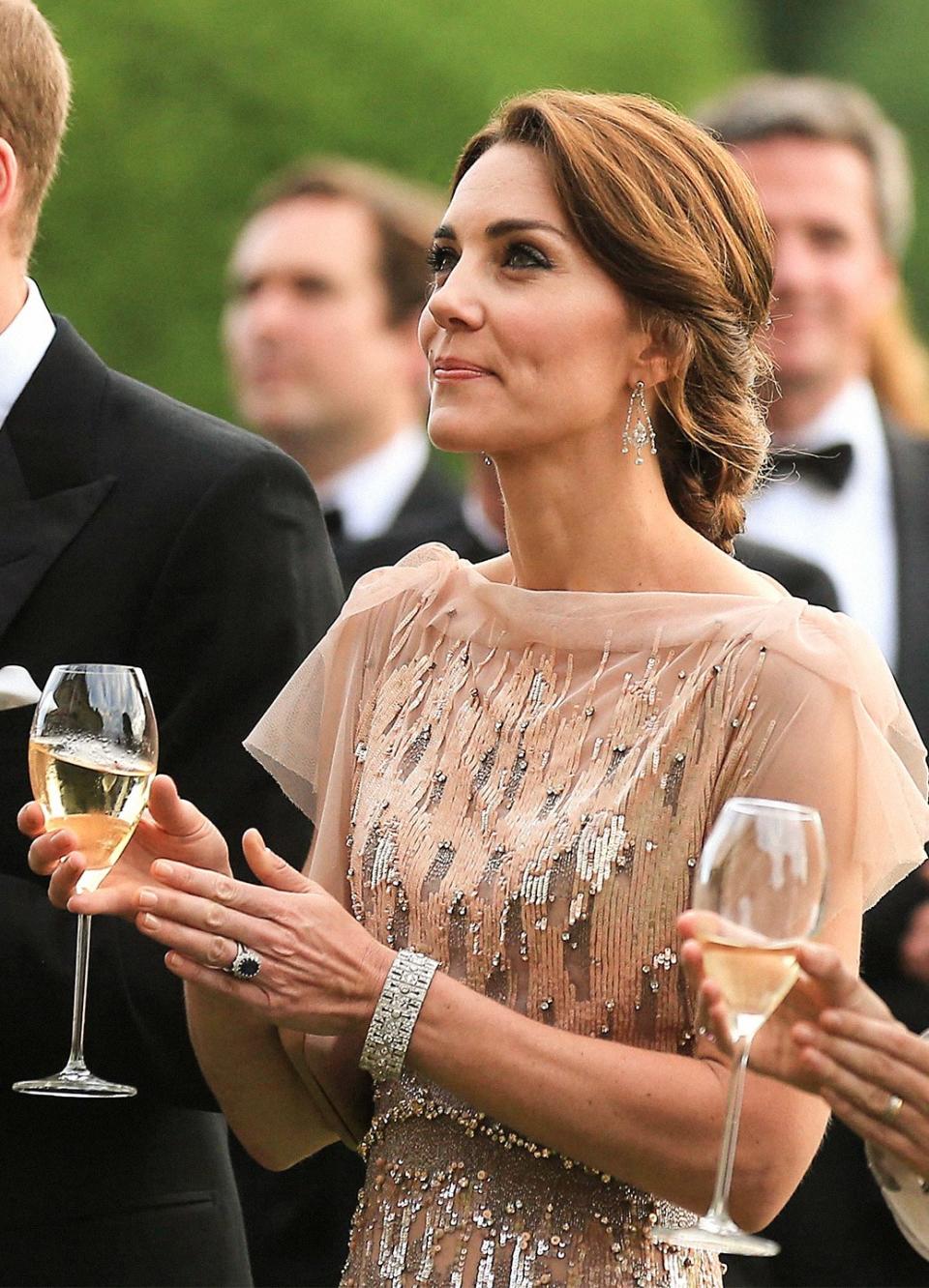 JUNE: Kate holding a glass of champagne—in an all-time-classic Middletonian gown, a repeat from 2011—makes this one of the more Platonic Ideal Kate photos. This should honestly be subbed in as her Wikipedia entry photo.