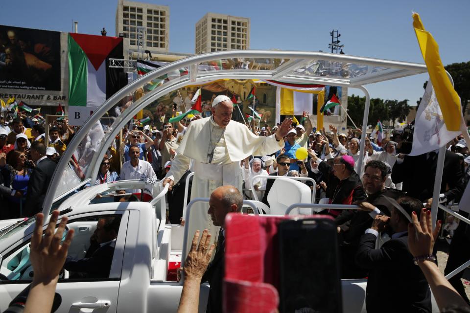 Pope Francis waves to the crowd as he arrives to give mass at Manger Square outside the Church of Nativity in in the West Bank city of Bethlehem