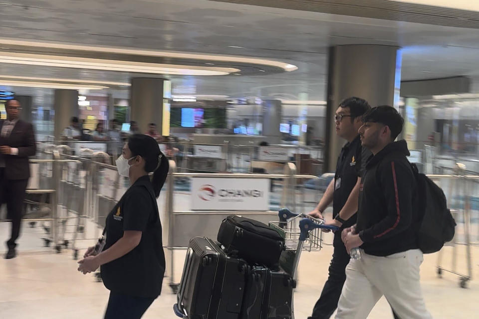 A passenger, with backpack at right, arrives from Bangkok at a Singapore airport Wednesday, May 22, 2024. A Singapore Airlines flight from London's Heathrow airport to Singapore was diverted and landed in stormy weather in Bangkok on Tuesday. (AP Photo)