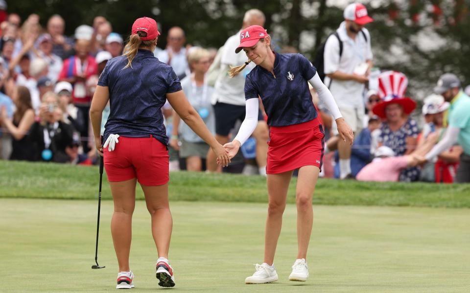 Sarah Schmelzel and Lauren Coughlin of Team United States react to her putt on the second green during the Friday Fourball matches against Team Europe during the first round of the Solheim Cup 2024 at Robert Trent Jones Golf Club on September 13, 2024 in Gainesville, Virginia