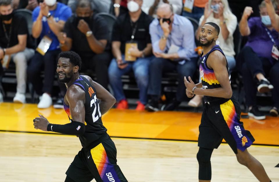 Phoenix Suns center Deandre Ayton (22) and Suns forward Mikal Bridges, right, run down the court after a Suns score against the Milwaukee Bucks during the second half of Game 1 of basketball's NBA Finals, Tuesday, July 6, 2021, in Phoenix. (AP Photo/Ross D. Franklin)