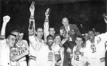 Gene Morse (center-left, holding coach's leg) celebrates an NIT championship with his Bradley University teammates in 1957.