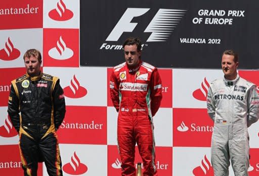 L to R: Lotus F1 Team's Finnish driver Kimi Raikkonen, Ferrari's Spanish driver Fernando Alonso and Mercedes' German driver Michael Schumacher celebrate on the podium at the Valencia Street Circuit in Valencia after the European Formula One Grand Prix