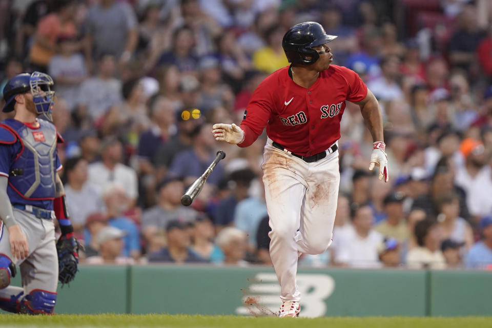 Boston Red Sox's Rafael Devers runs to first base after hitting an RBI double in front of Texas Rangers' Jonah Heim, left, during the third inning of a baseball game Thursday, July 6, 2023, in Boston. (AP Photo/Steven Senne)