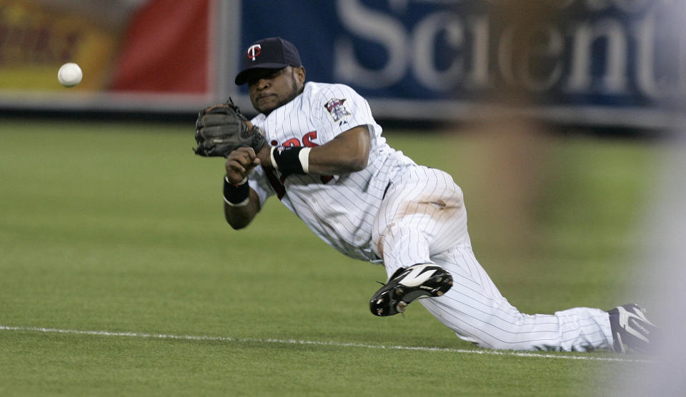 FILE - In this June 12, 2007 file photo, Minnesota Twins second baseman Luis Castillo makes an off-balance throw to first base in an unsuccessful attempt to throw out Atlanta Braves' Kelly Johnson on an infield single during the second inning of a baseball game in Minneapolis. Authorities in the Dominican Republic arrested on Tuesday, Aug. 20, 2019, former MLB pitcher Octavio Dotel and are searching for ex-infielder Luis Castillo for their alleged links to a drug-trafficking and money-laundering ring in the Caribbean and United States. (AP Photo/Ann Heisenfelt, File)