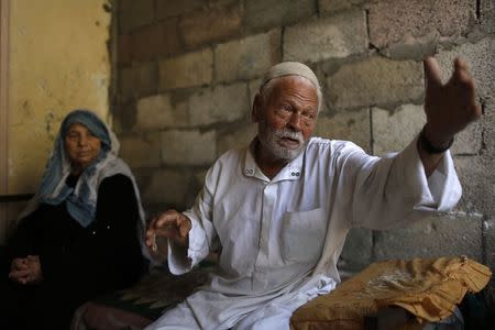 Ibrahim Mohammad al-Toum, 85, gestures near his wife, Amena Khalid al-Toum, 75, at their home that they say has been bombed three times in six years by the Israeli army, in Gaza City, August 11, 2014. REUTERS/Siegfried Modola