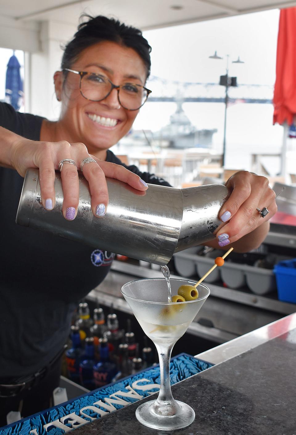 Ashley Woods, bartender at the Cove, pours a dirty martini at the deck bar.