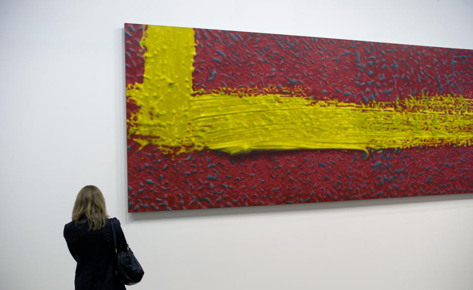 A member of media stands by "Stroke (on red)" a 1980 painting by German artist Gerhard Richter on the eve of the opening of the exhibition "Gerhard Richter: Panorama", at the Centre Pompidou, Monday, June 4, 2012. (AP Photo/Thibault Camus)