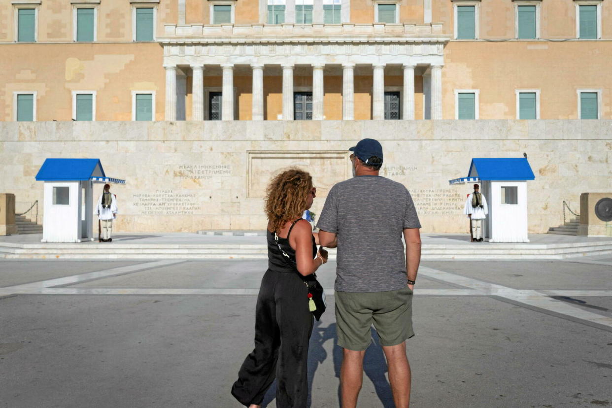 Des touristes devant le Parlement grec, à Athènes, alors qu'une vague de chaleur touche le pays, le 16 juillet 2023.   - Credit:George Schinas/NurPhoto via AFP