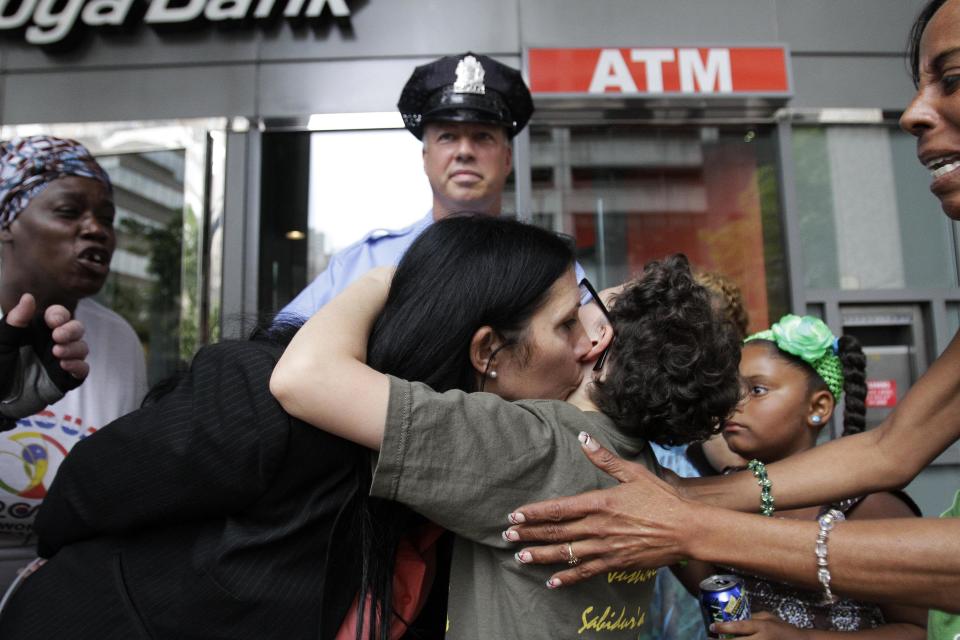 Green Party vice presidential nominee Cheri Honkala kisses her son, Guillermo Santos, 10, before she was arrested during a sit-in at a downtown Philadelphia bank over housing foreclosures, Wednesday, Aug. 1, 2012, in Philadelphia. About 50 Green Party supporters hope to protest at Fannie Mae. (AP Photo/Brynn Anderson)