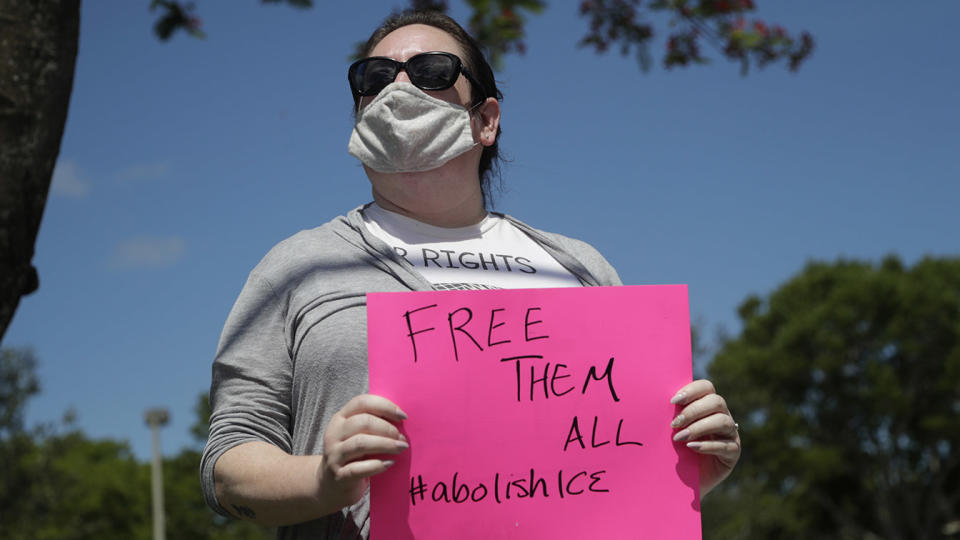 Sarah Bosch-McGuinn wears a protective face mask as she protests outside of a U.S. Immigration and Customs Enforcement field office during the new coronavirus pandemic, Friday, May 29, 2020, in Plantation, Fla. (Lynne Sladky/AP)