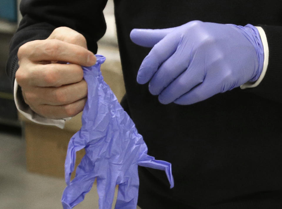 In this Wednesday, Feb. 5, 2014 photo, Chris Woods, director of London's National Conservation Service, dons a pair of special gloves to handle the Magna Carta, in Houston. The centuries old parchment, one of only four remaining copies of the original document issued by the King of England, will be on display at the Houston Museum of Natural Science for six months starting Feb. 14, 2014. (AP Photo/Pat Sullivan)