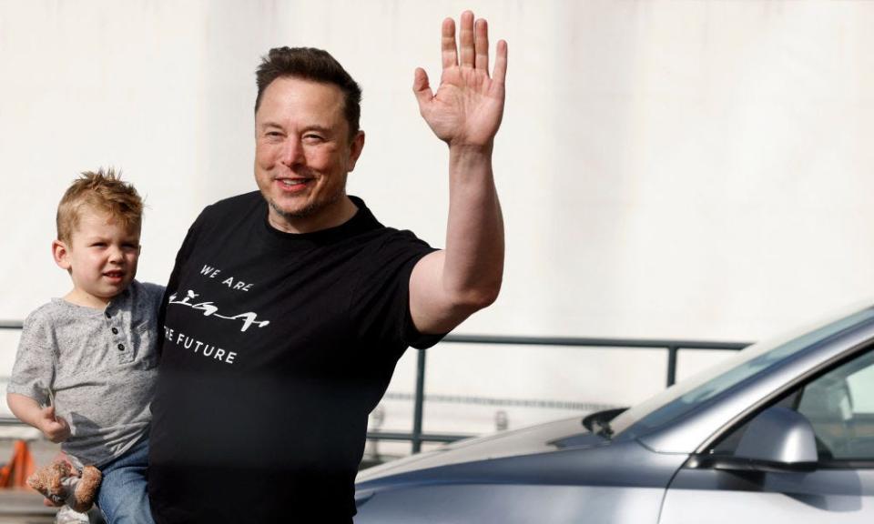 Elon Musk holds his child