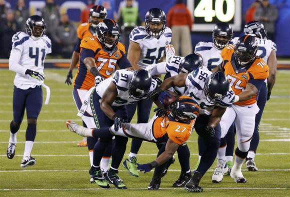 Broncos Moreno is tackled by Seahawks Clemons during the NFL Super Bowl XLVIII football game in East Rutherford