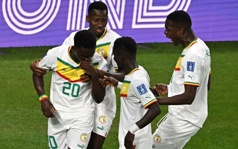 Bamba Dieng (L) celebrates scoring his team's third goal with his teammates during the Qatar 2022 World Cup Group A football match between Qatar and Senegal at the Al-Thumama Stadium - AFP